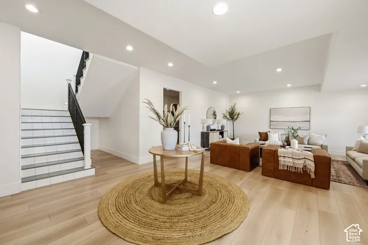Entry from front door into lower level living room with tall ceilings and abundant natural light.