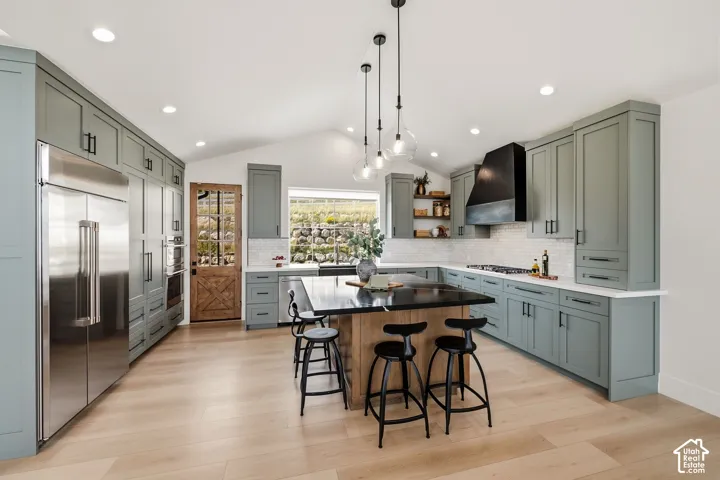 Vaulted ceiling kitchen featuring sage cabinetry and high end caf