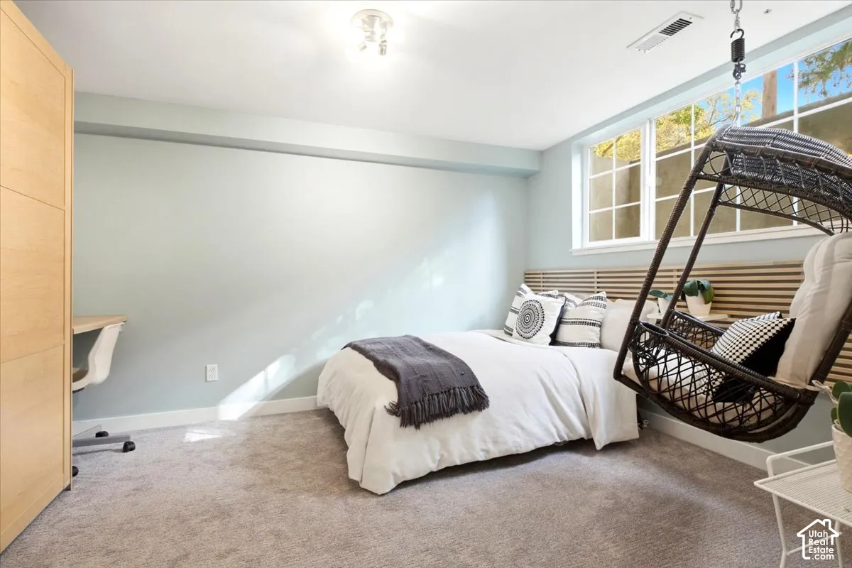 Wall-to-wall carpeting, built-in shelving, multi-pane windows, and a slatted wood headboard