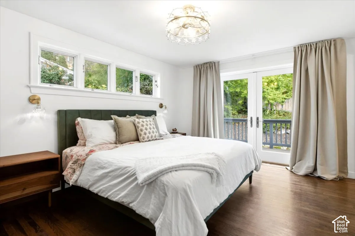 Hardwood flooring, transom windows, French doors, balcony access, and a decorative ceiling fixture