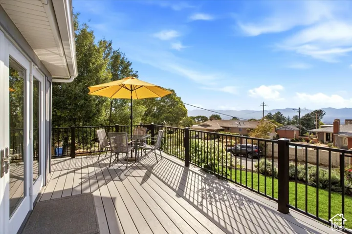 Expansive outdoor deck with composite decking, black metal railings, and dual glass-paneled doors