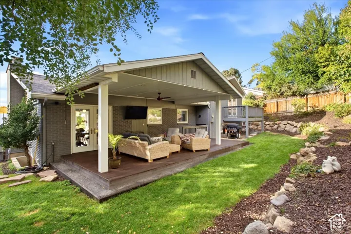 Expansive covered deck with ceiling fan, providing a generous outdoor living area
