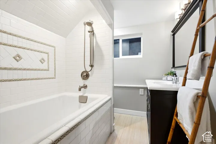 Built-in bathtub with subway tile surround and decorative tile inlay