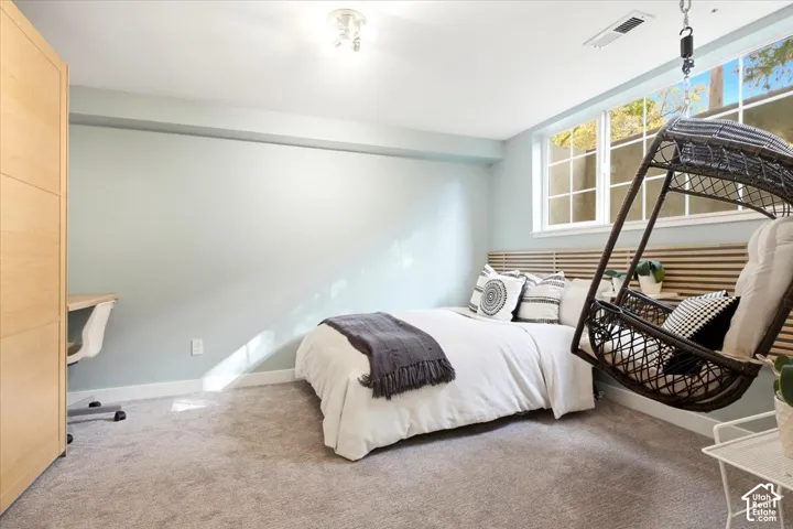 Wall-to-wall carpeting, built-in shelving, multi-pane windows, and a slatted wood headboard
