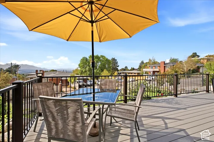 Expansive outdoor deck with composite decking, black metal railing, and distant mountain scenery