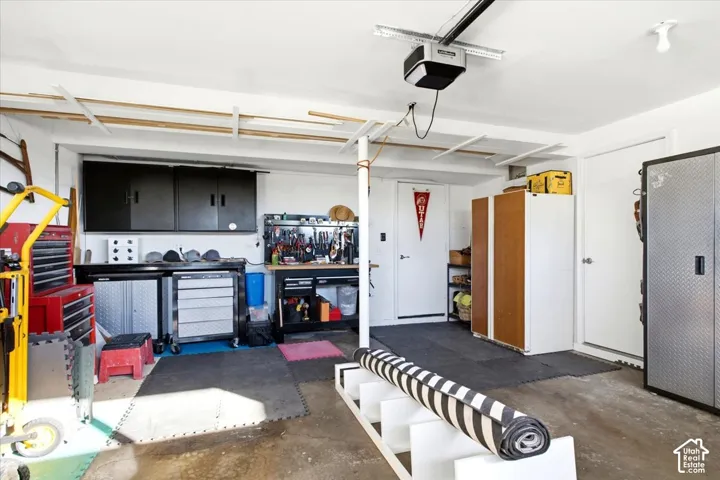 Attached garage space with painted concrete flooring and overhead garage door opener