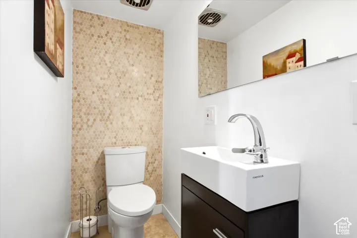 Hexagon tile accent wall, contemporary vessel sink, dark wood-finish vanity, polished chrome faucet, full-width mirror
