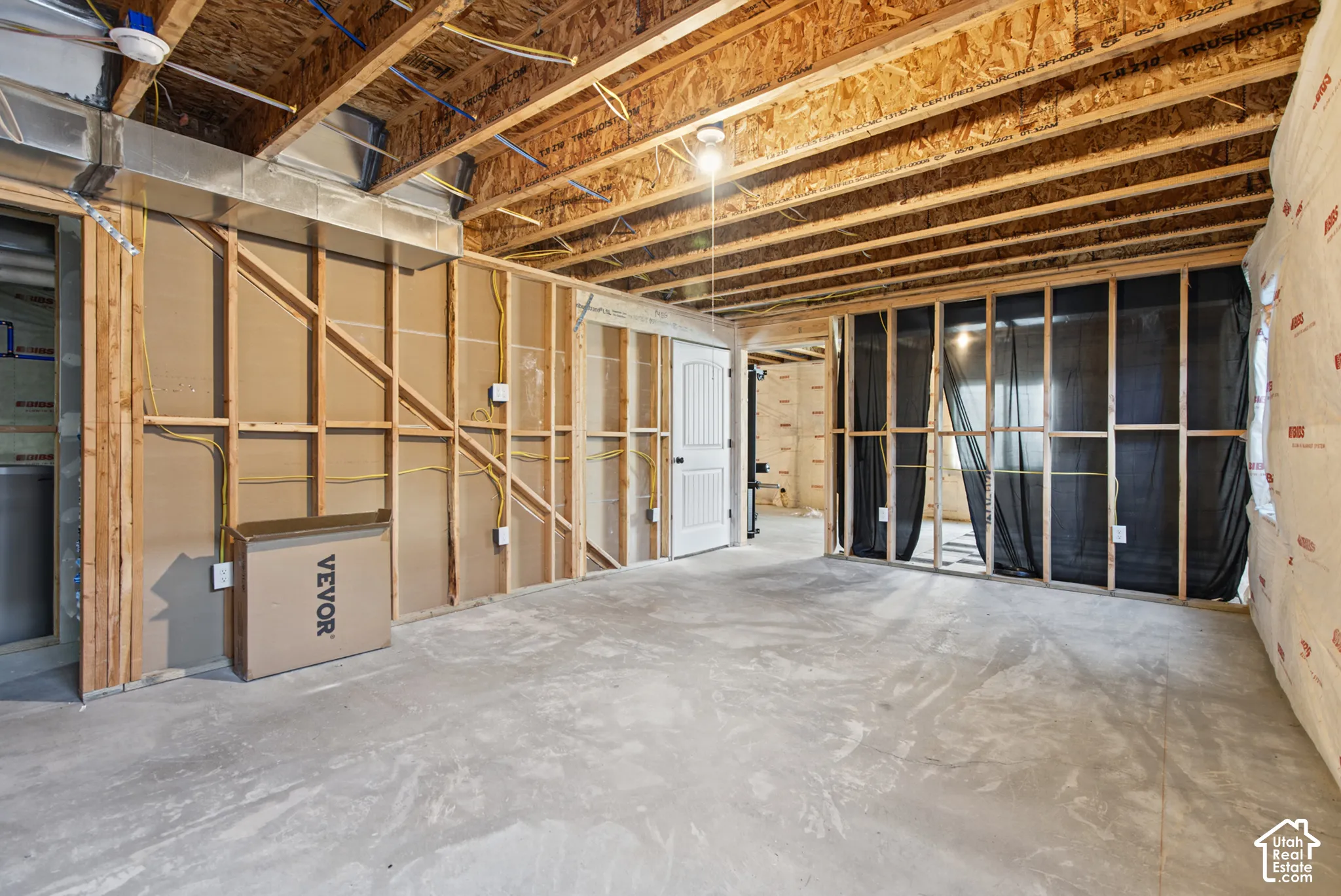 Unfinished basement featuring exposed wood joists and concrete flooring
