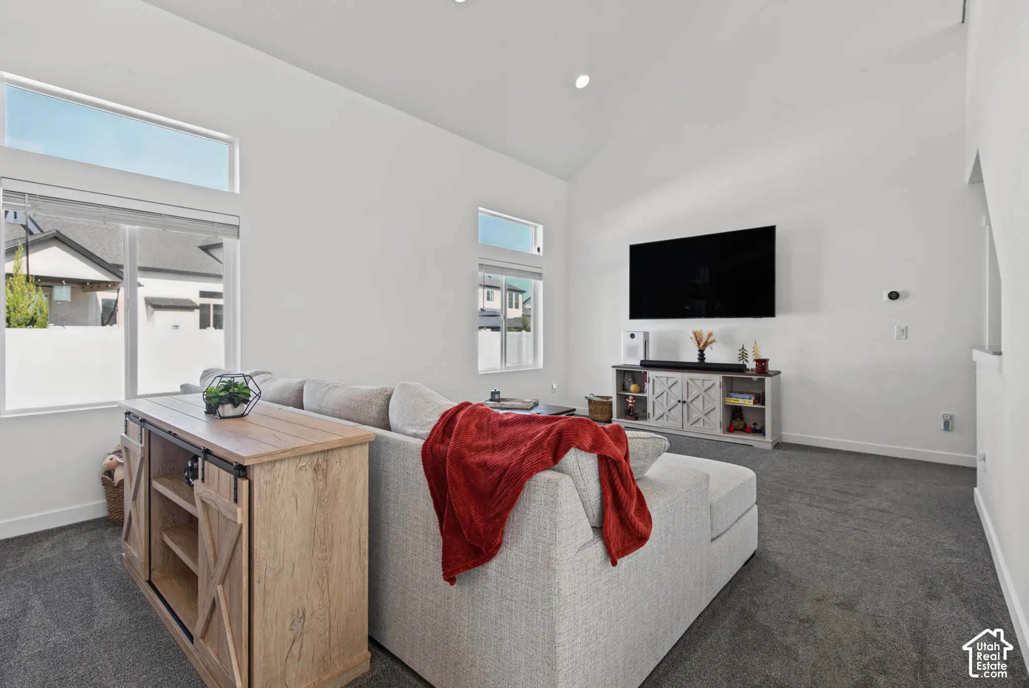 Vaulted ceilings, recessed lighting, and large windows with transom accents