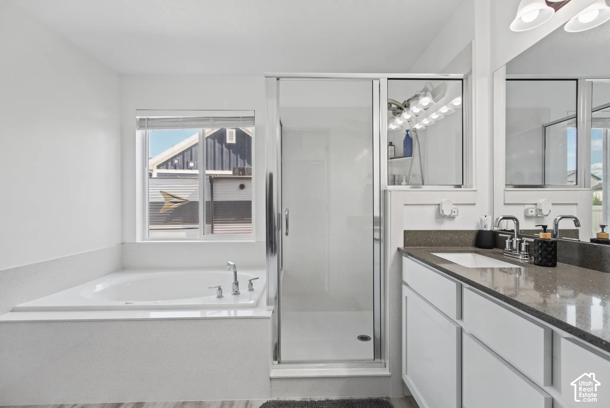 Built-in soaking tub, glass-enclosed shower, dual vanity with undermount sinks, and quartz countertops