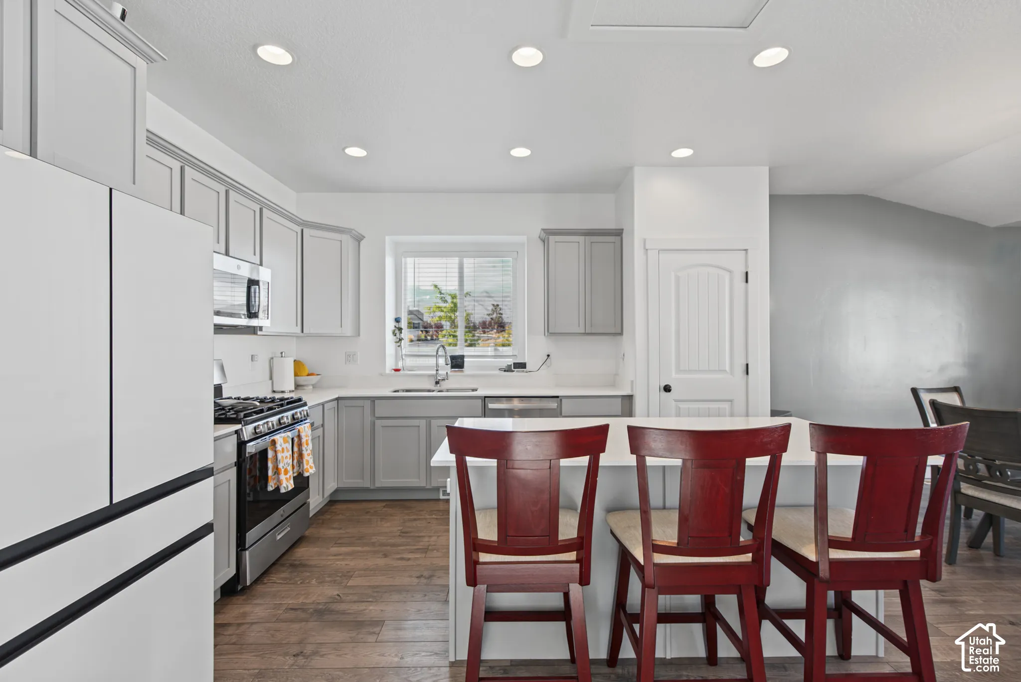 Kitchen featuring wood-finish flooring, recessed lighting, and a white countertop island