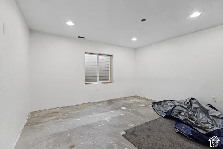 Recessed ceiling lighting, white painted walls, and a single window