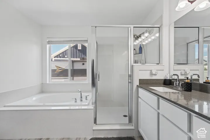 Built-in soaking tub, glass-enclosed shower, dual vanity with undermount sinks, and quartz countertops