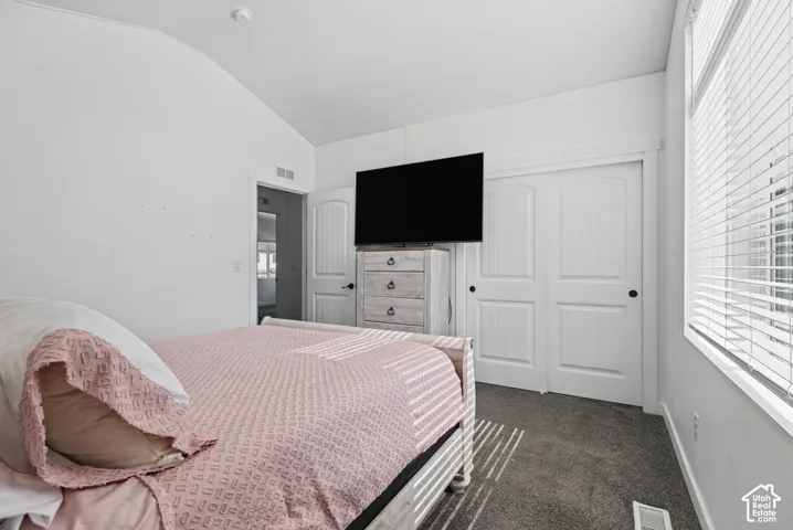 Vaulted ceiling in a room with carpeted flooring
