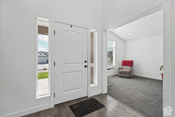White entry door with vertical paneling, flanked by clear sidelight windows