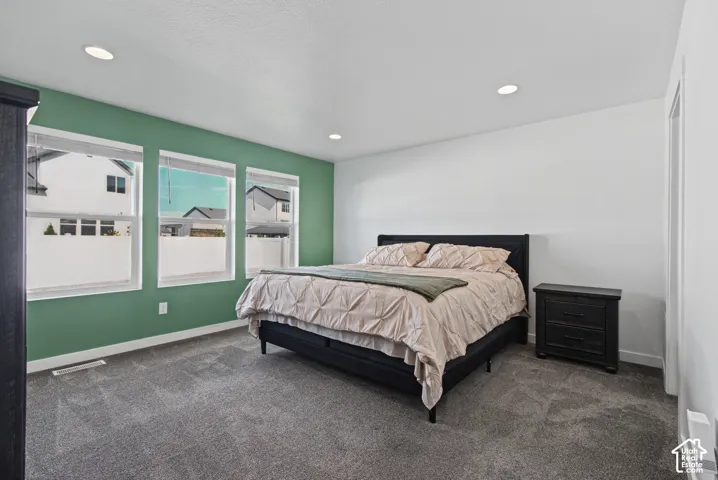 Recessed lighting, three windows with blinds, and wall-to-wall carpeting