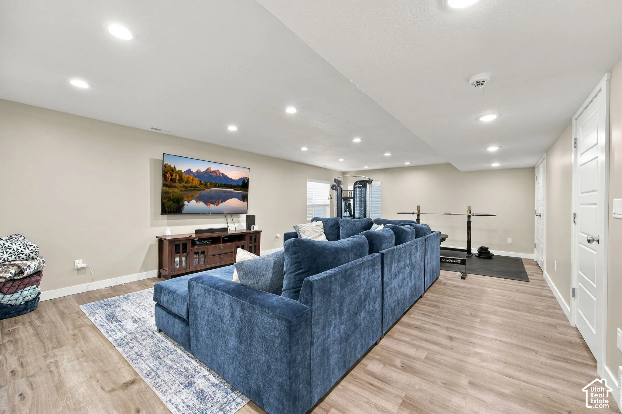Recessed lighting, wood-finish flooring, two panel interior doors, and a wall-mounted television