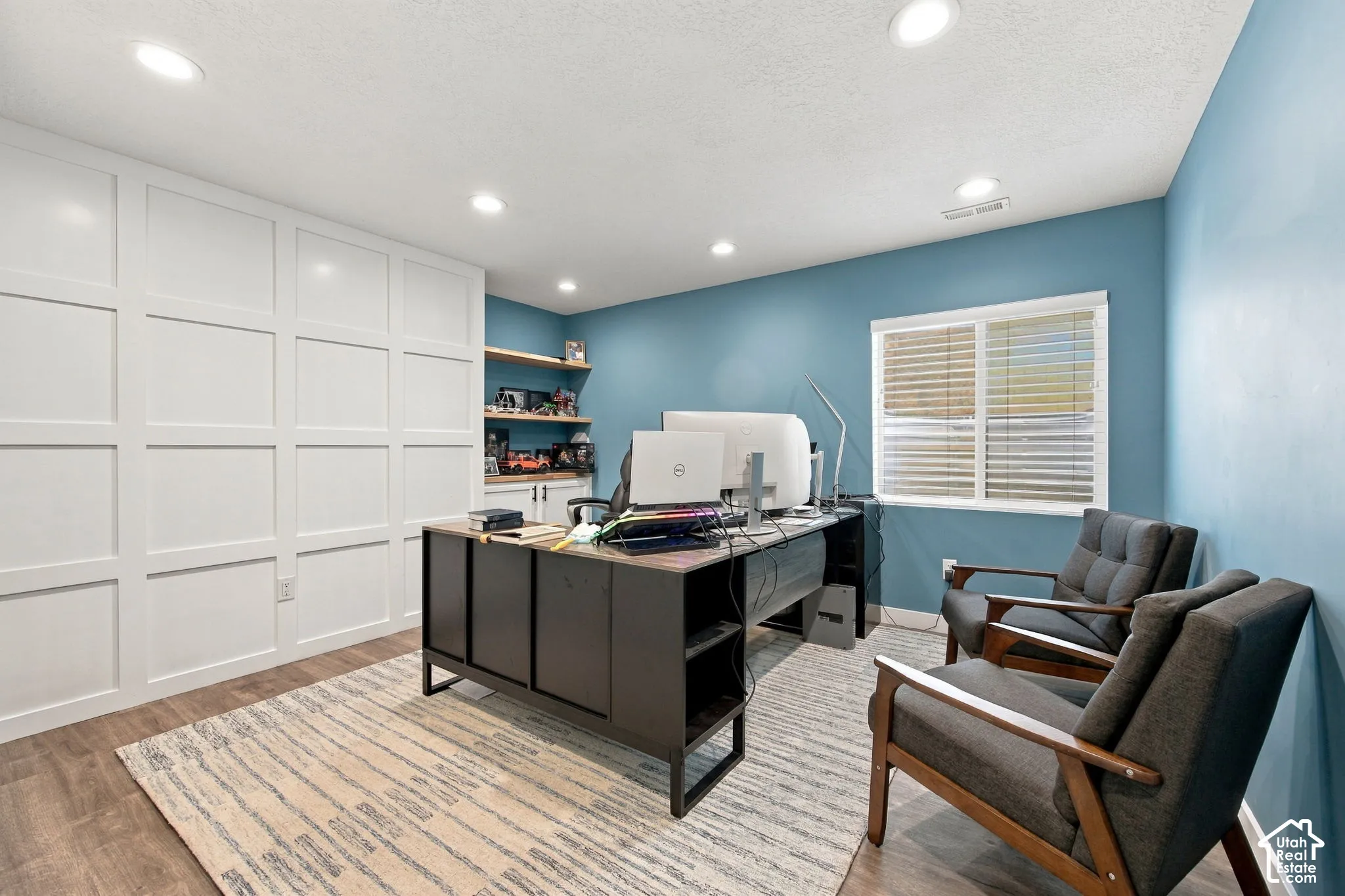 Bedroom 7 - Wood-finish flooring with recessed lighting, complemented by a window with blinds and built-in shelving