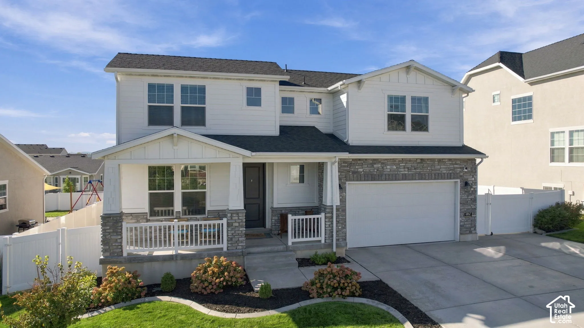 Two-story residence featuring a covered front porch, an attached two-car garage, and a concrete driveway