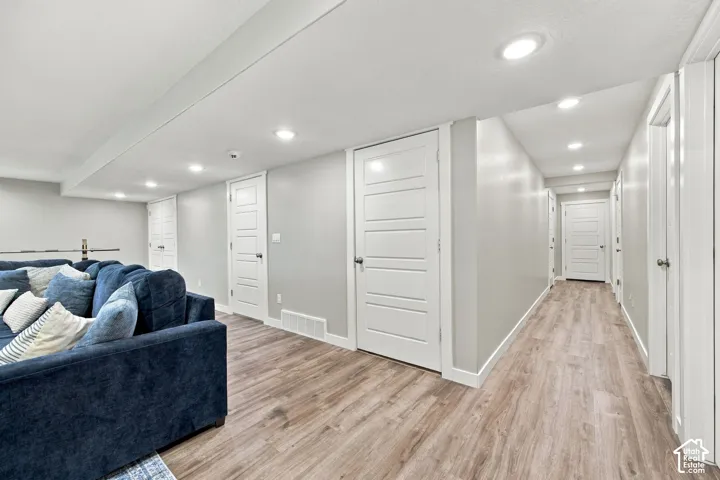 Wood-finish flooring throughout, recessed lighting, and multiple white panel doors