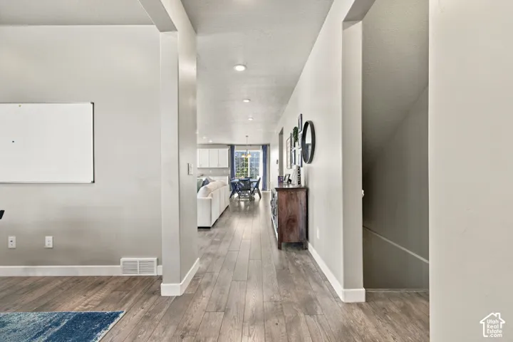 Wood-finish flooring throughout, recessed lighting, and a neutral wall color