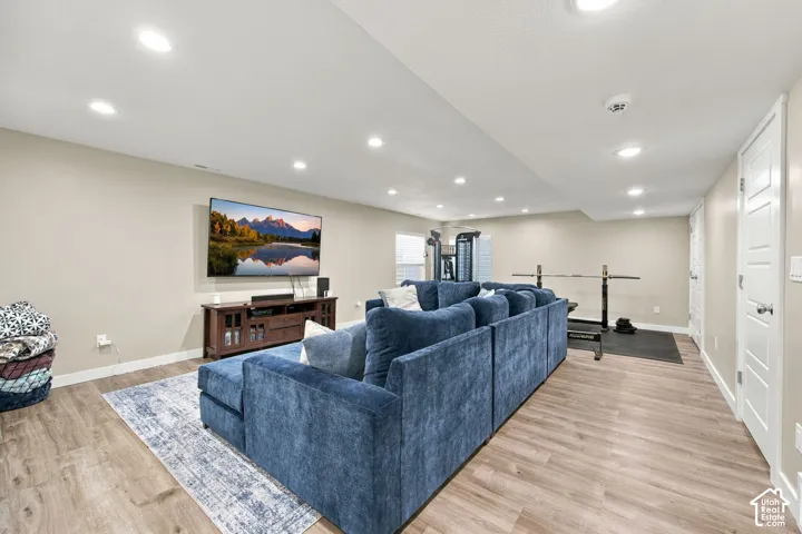 Recessed lighting, wood-finish flooring, two panel interior doors, and a wall-mounted television