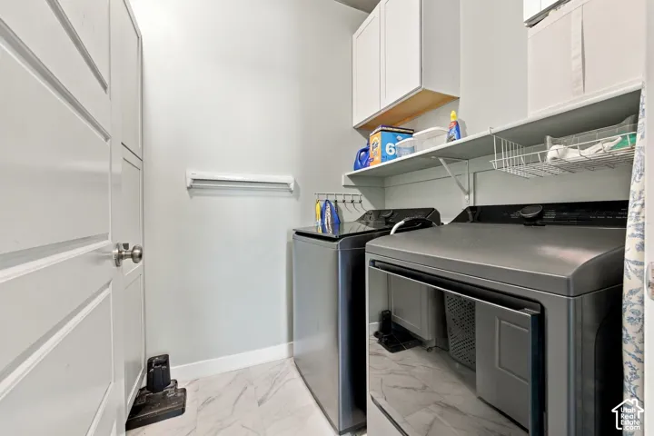 Built-in overhead white cabinetry, integrated shelving, and marble-look tile flooring