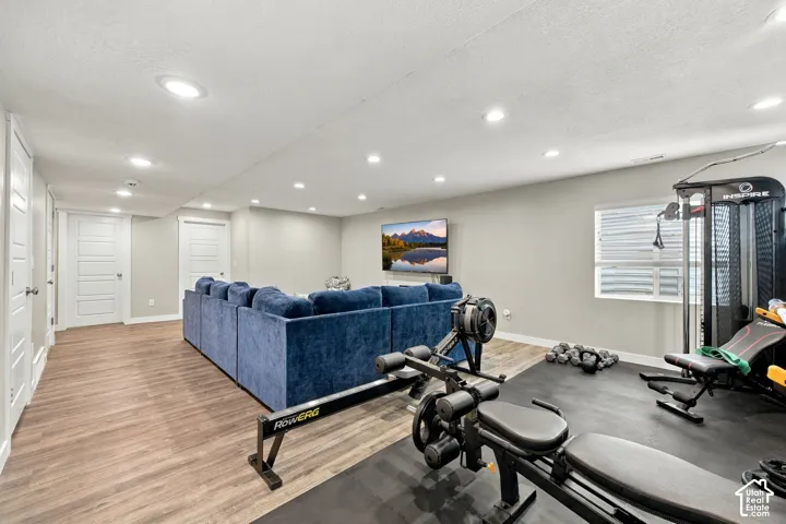 Recessed lighting illuminates wood-finish flooring throughout the open space