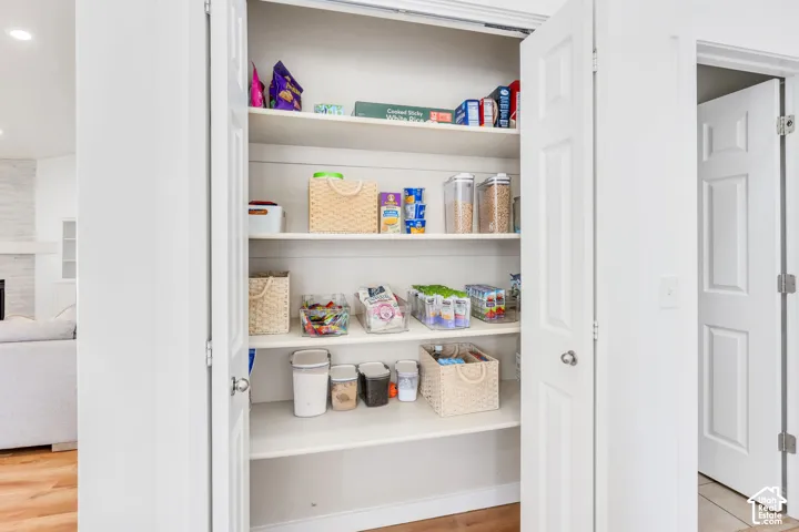 Built-in pantry with multiple shelving levels and white bi-fold doors