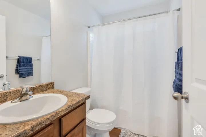 Bathroom featuring a vanity with an integrated sink, a speckled countertop, and wood-finish cabinetry