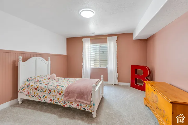 Wall-to-wall carpeting, window with blinds, ceiling-mounted light fixture, and beadboard wall paneling