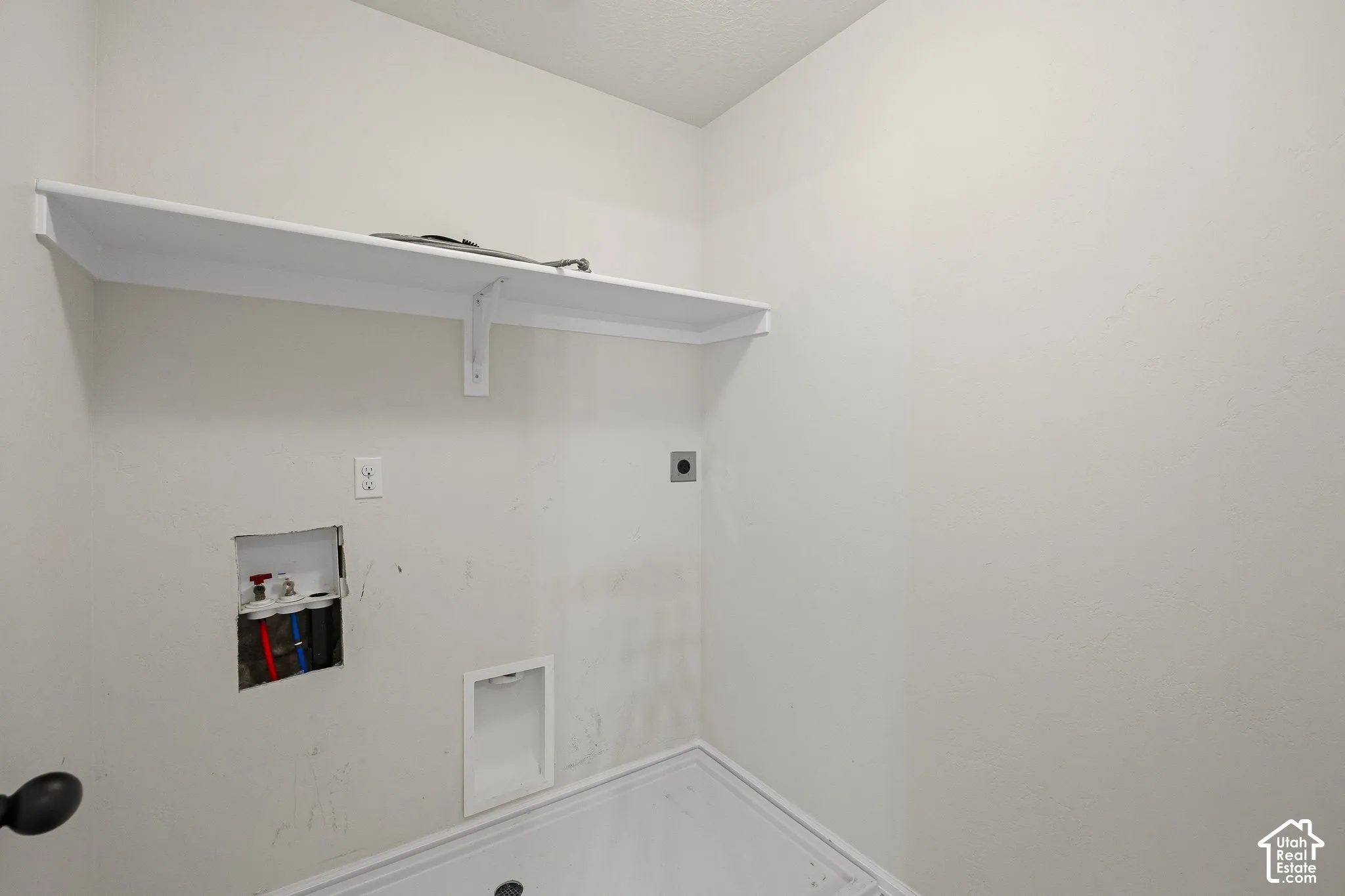 Built-in shelf, appliance hookups, and light-toned walls