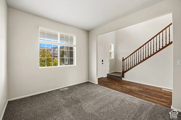 Bright interiors featuring a large multi-pane window with horizontal blinds, neutral wall paint, and plush carpeting