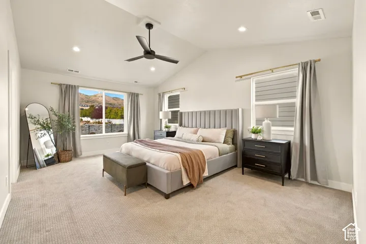 Vaulted ceiling with an integrated ceiling fan, recessed lighting, and multiple windows with mountain scenery