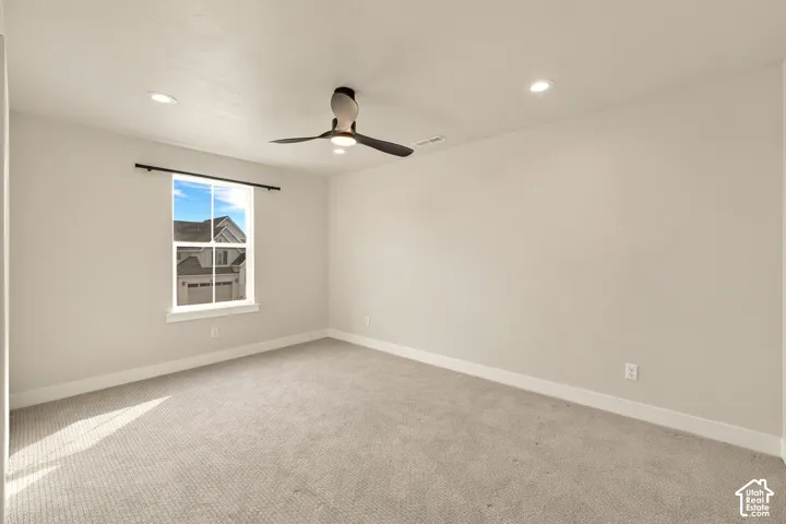 Carpeted interior with recessed lighting, a ceiling fan, and a window with white trim