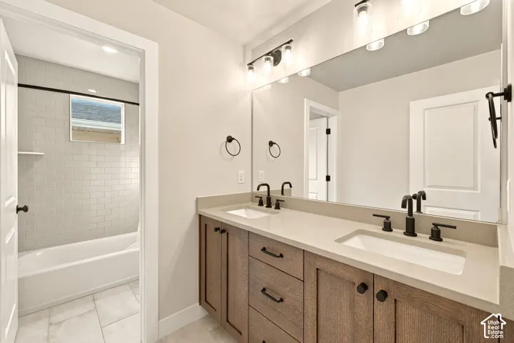 Dual vanity with wood-finish cabinetry, light-toned countertop, and matte black fixtures