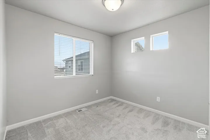 Neutral wall color, wall-to-wall carpeting, recessed ceiling lighting, and multiple windows