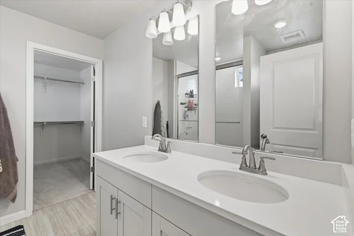 Dual vanity with white shaker-style cabinetry, white countertops, and brushed nickel fixtures