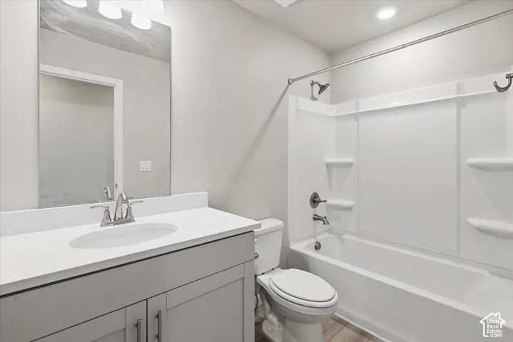 White countertop vanity with undermount sink, brushed nickel faucet, and a large wall mirror