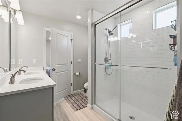 Dual vanity with undermount sinks, a walk-in shower with subway tile surround, and a glass shower enclosure