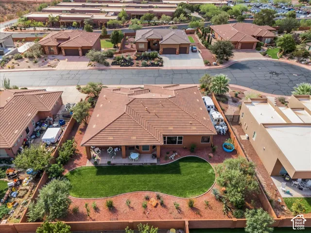 Expansive backyard with a manicured lawn, established landscaping, and covered patio