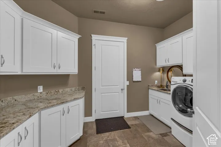 White shaker cabinetry, light-toned countertops, and a built-in sink