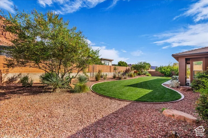 Expansive lawn area with a curved edge, surrounded by decorative rock landscaping