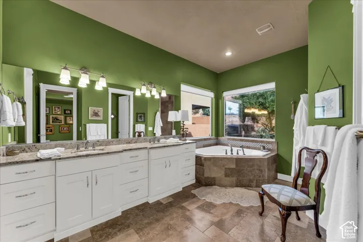 Dual vanity with white cabinetry, stone countertops, and integrated sinks
