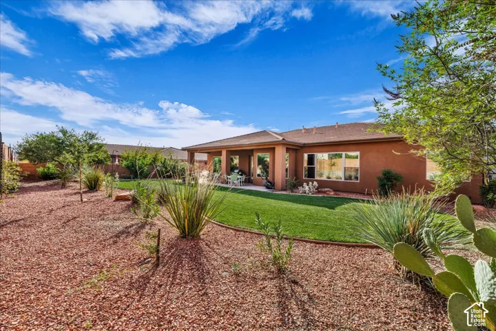 Expansive backyard with a manicured lawn, red gravel landscaping, and mature desert plantings