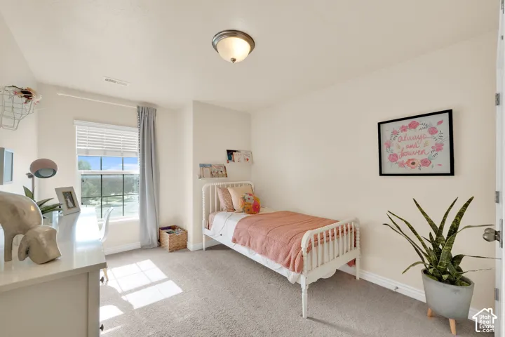 Neutral tone wall color, carpet flooring, window with blinds and drapes, flush mount ceiling light fixture, white trim throughout