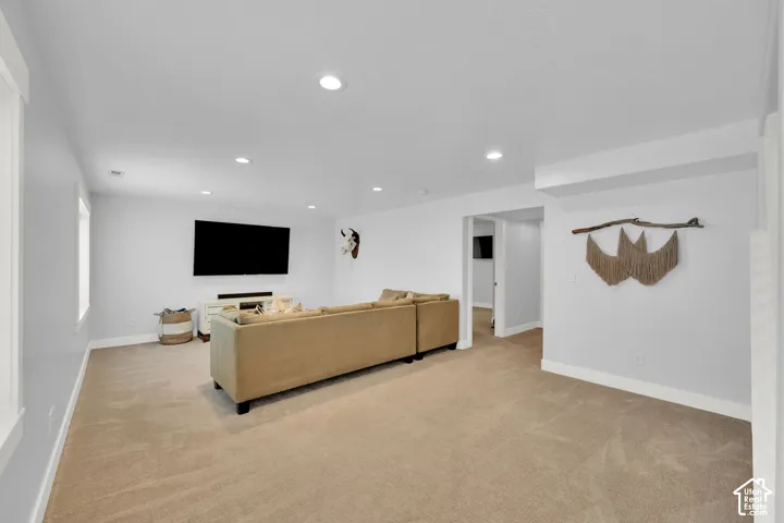 Recessed lighting, light gray painted walls, and neutral carpeting