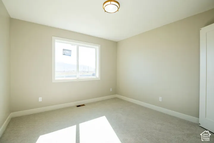 Neutral wall color, wall-to-wall carpeting, recessed window, white trim, and a ceiling-mounted light fixture