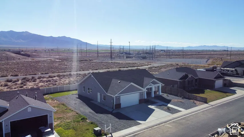 Single-story residence featuring a two-car garage, concrete driveway, and gravel landscaping