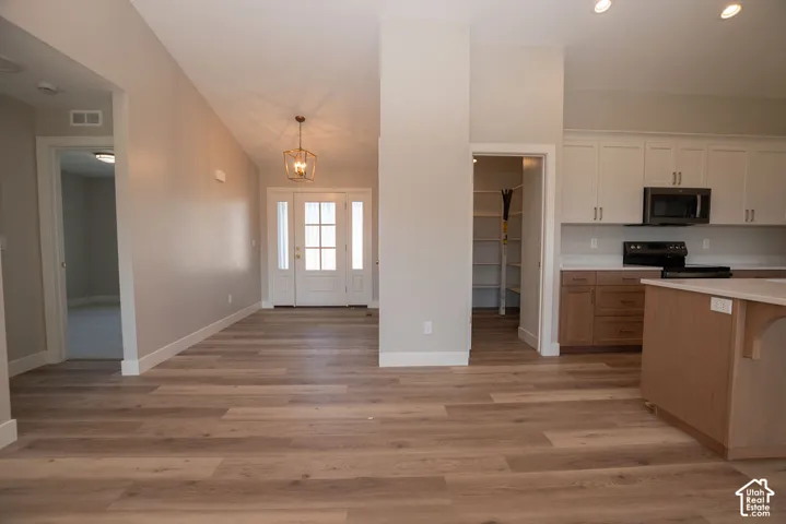 Wood-finish flooring throughout, vaulted ceiling, and recessed lighting
